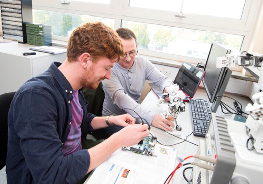 Two men collaborating on electronics projects,