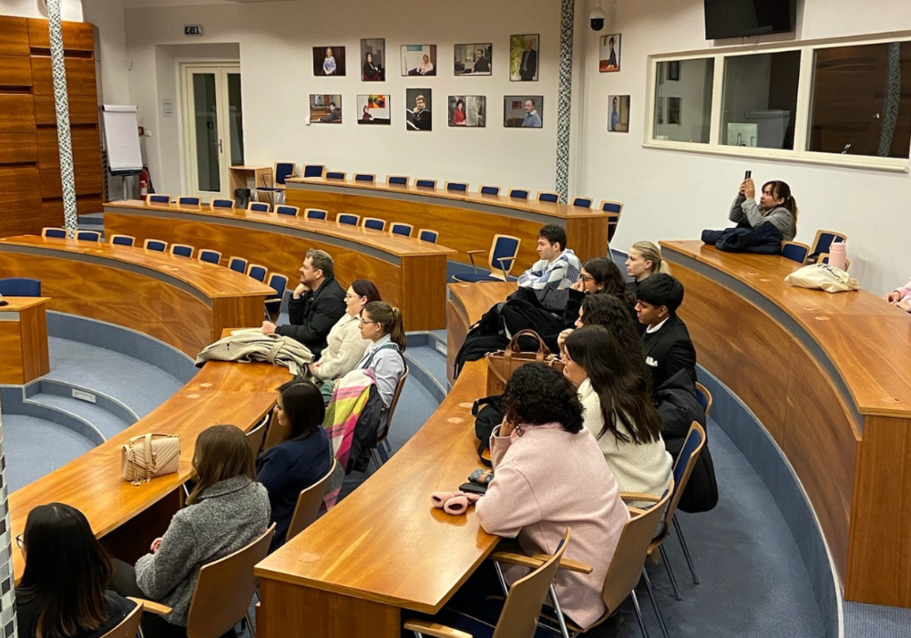 A group of people attentively sitting in a lecture hall.
